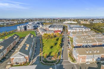 an aerial view of campus with a green park in the middle of the road  at Harbor Pointe, Bayonne, NJ